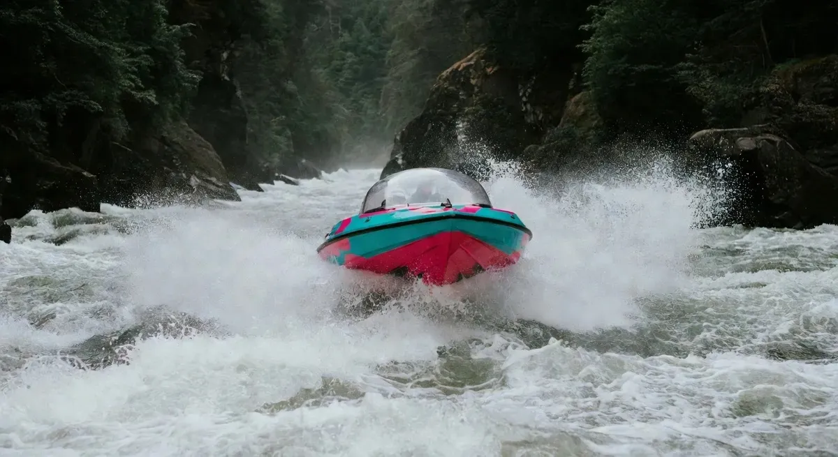 The Whirlpool Jet Freedom Boat No. 18 crashing through white water rapids in the Niagara Gorge on a Niagara Falls jet boat tour — iconic domed vessel in action