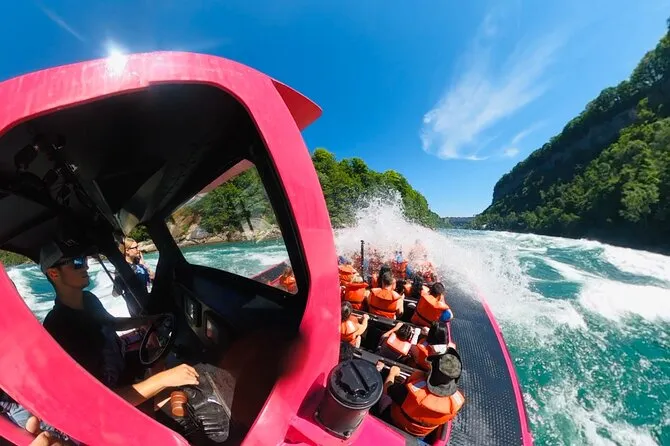 Riders on an open-top wet jet boat racing through Class 5 whitewater rapids in the Niagara Gorge on a Niagara Falls jet boat tour from Lewiston NY
